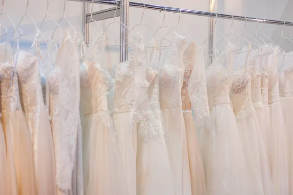 Stojak z wielu pięknych sukien ślubnych. — Zdjęcie stockowe