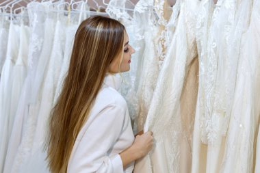 Düğün salonundaki kadın gelinlik seçiyor..