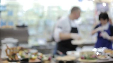 Asistanı olan şef yemek hazırlıyor. Bulanık video.