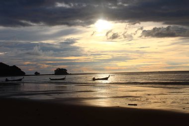Sahilde inanılmaz bir gün batımı iki kayığın yüzdüğü yerde.