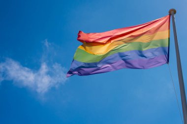 LGBT gurur bayrağı dalgalanıyor mavi gökyüzünde 