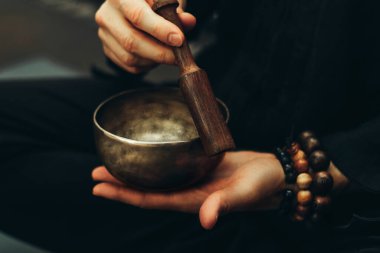 Şarkı kaselerinde tespih çalan ellerin yakın çekimi. Rahatlama ve meditasyon. Alternatif tıp. Tibetli ve Himalaya şarkı kaseleri. Ses çıkar..