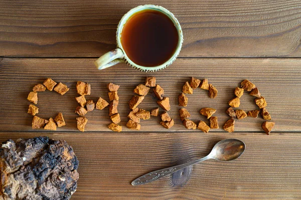 chaga tea mushroom from birch tree using for healing tea or coffee in folk medicine. the word chaga, laid out from pieces of the chaga mushroom