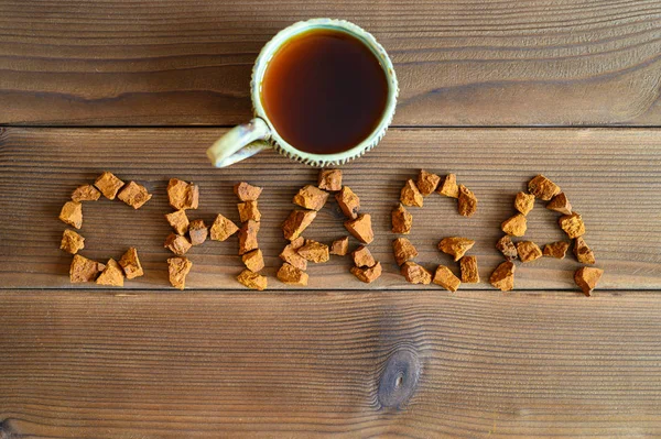 chaga tea mushroom from birch tree using for healing tea or coffee in folk medicine. the word chaga, laid out from pieces of the chaga mushroom