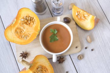 Kabak püresi çorbası, balkabağı, ahşap beyaz arka planda baharatlar..