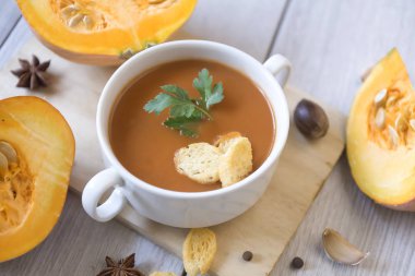 Kabak püresi çorbası, balkabağı, ahşap beyaz arka planda baharatlar..