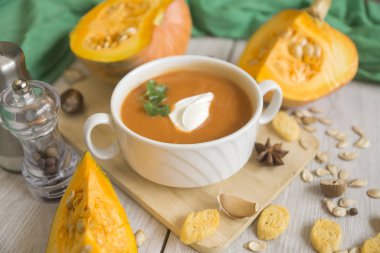 Kabak püresi çorbası, balkabağı, ahşap beyaz arka planda baharatlar..