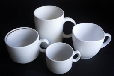 Büyük, orta, küçük fincanlar koyu arka planda kahve için..