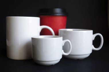 Büyük, orta, küçük fincanlar koyu arka planda kahve için..