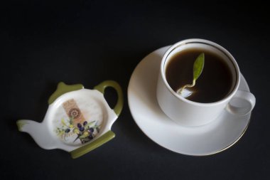 Koyu arkaplanda bir fincan taze demlenmiş siyah çay..