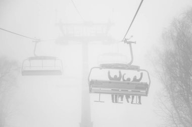 Ski lift with people through snow blizzard in Bakuriani, Georgia