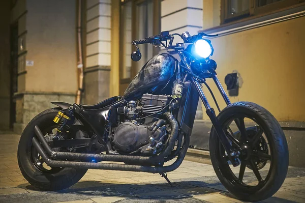 Tbilisi, Georgia August 10, 2019 Custom Kawasaki Vulcan Bobber Motorcycle parked on the side of the road at night