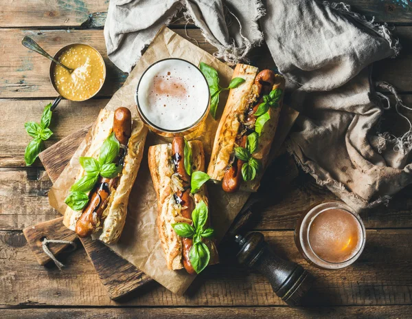 Trigo cerveja não filtrada e cães de salsicha grelhados em baguete — Fotografia de Stock