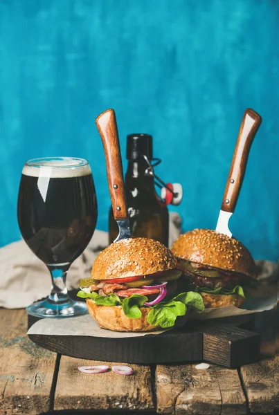 Hambúrgueres de carne com bacon crocante, legumes e cerveja escura — Fotografia de Stock