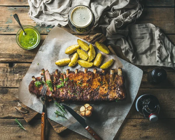 Roasted pork ribs with sauce, fried potato and dark beer — Stock Photo, Image