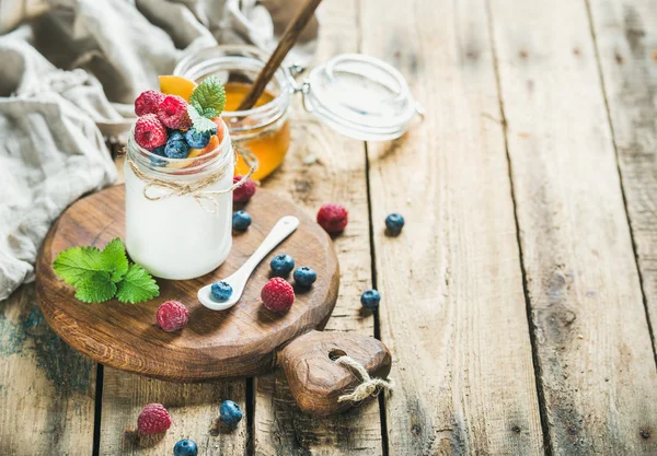Glass jar of yogurt with berries, mint and honey — Stock Photo, Image