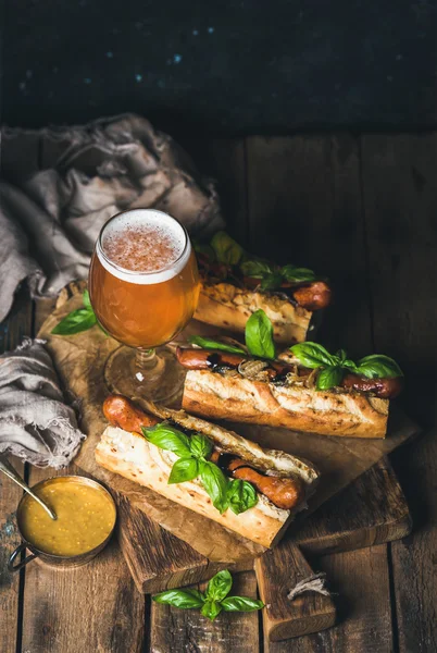 Sklo a láhev piva nefiltrovaná, grilovaná klobása psy — Stock fotografie