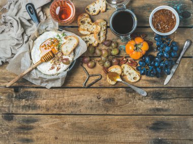 Camembert peyniri, meyve, ekmek, bal, fındık, reçel ve gül şarap