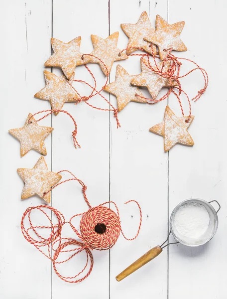 Biscoitos em forma de estrela de gengibre de Natal com açúcar em pó, corda vermelha — Fotografia de Stock