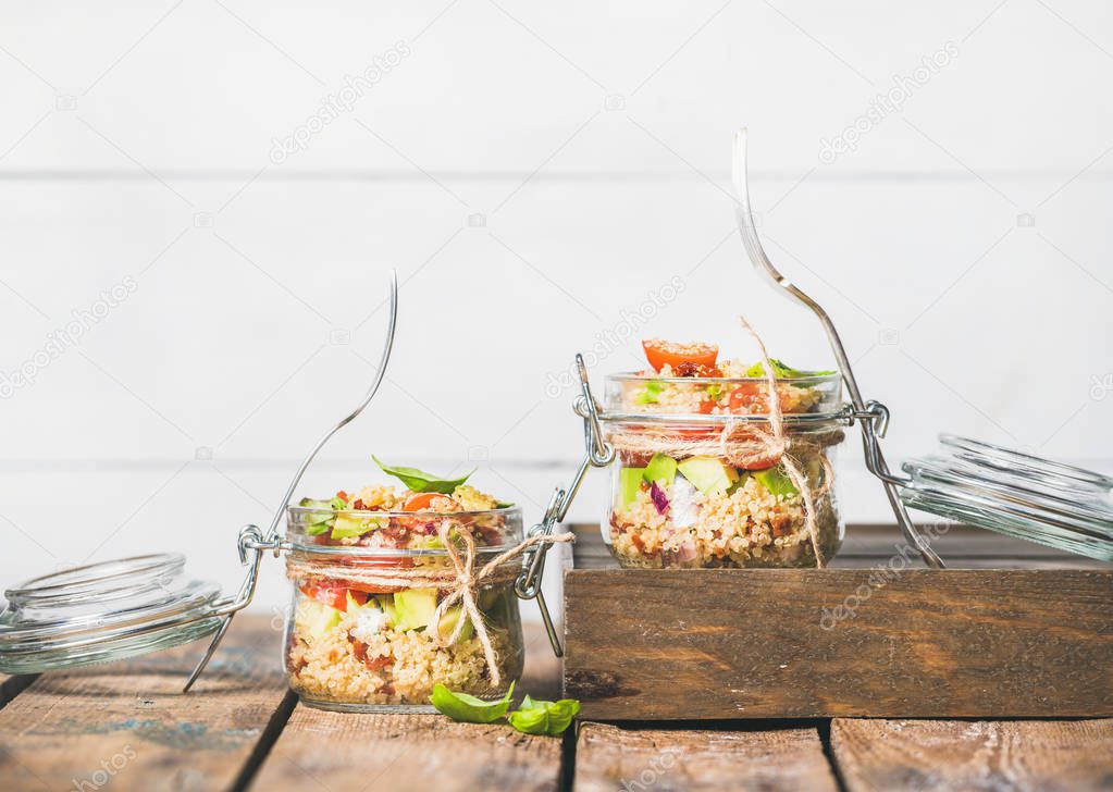 Healthy homemade quinoa salad with tomatoes, avocado, basil in jars