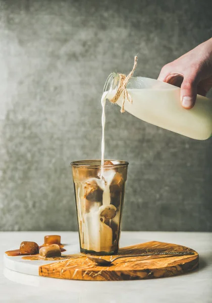 Mão do homem derramando leite para café — Fotografia de Stock