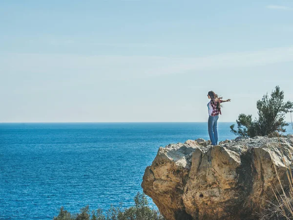 Menina de pé na rocha sobre o mar — Fotografia de Stock