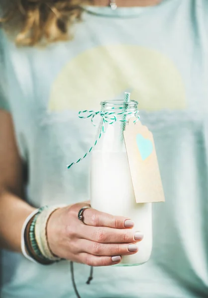 Mulher segurando garrafa de leite de amêndoa — Fotografia de Stock