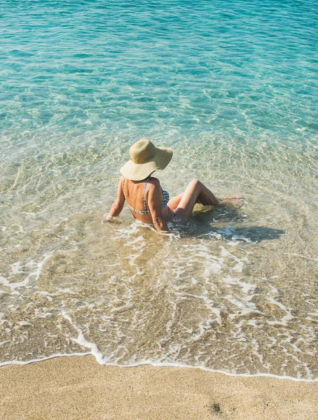 Mulher de biquíni sentado em águas do mar — Fotografia de Stock