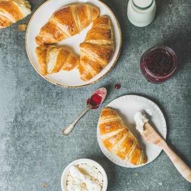 Kruvasan ile reçel, krem peynir ve süt 