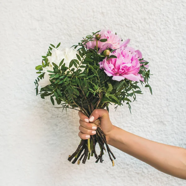 Bouquet of peony flowers in hand