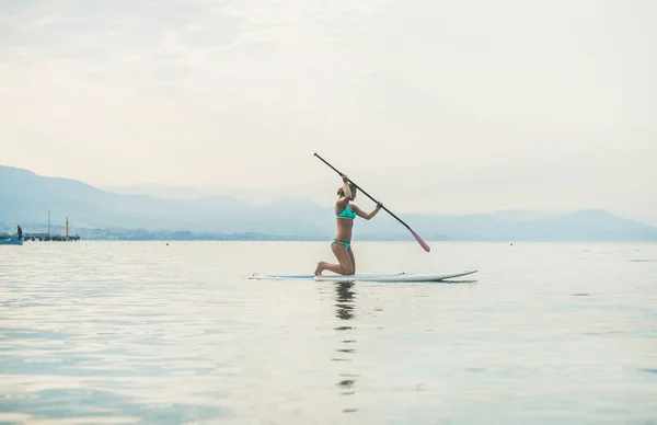 Mulher praticando paddle boarding — Fotografia de Stock