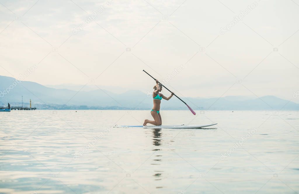 woman practicing paddle boarding