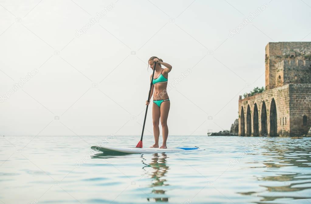 woman practicing paddle boarding