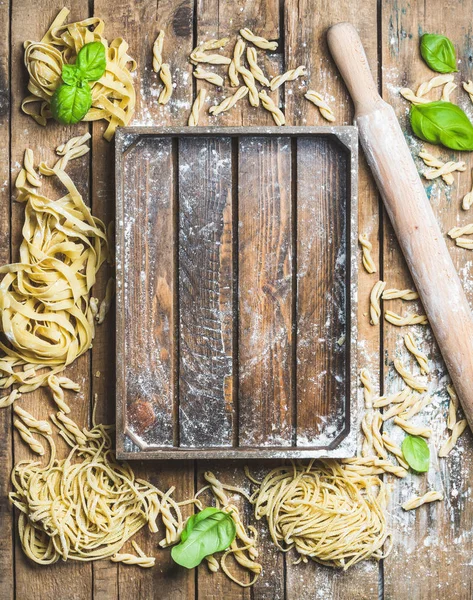 Ungekochte italienische Pasta und hölzerne Tablett — Stockfoto