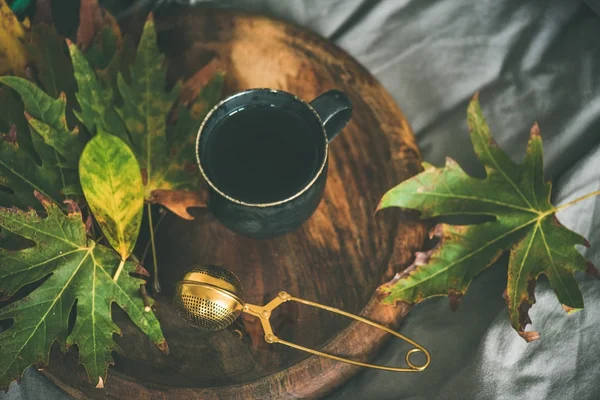 Tasse de thé avec tamis et feuilles d'automne — Photo