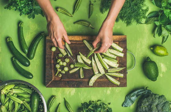 Kvinnan skära gröna grönsaker och gröna — Stockfoto