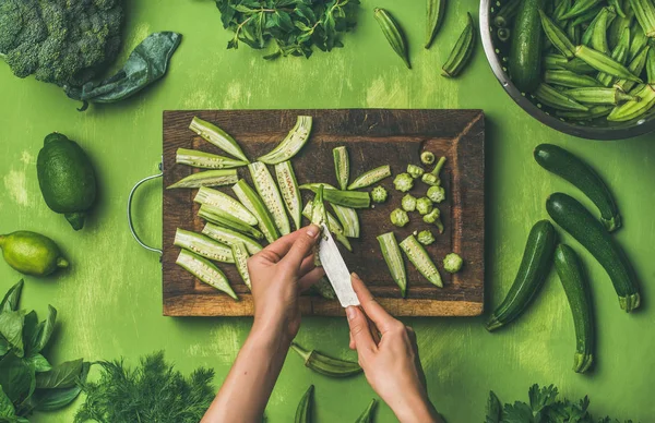 Жінка ріже зелені овочі та зелень — стокове фото