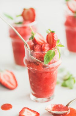 Healthy low calorie summer treat. Strawberry and champaigne granita, slushie or shaved ice dessert in glasses with mint, white background clipart