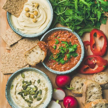 Vegan aperatif kurulu. Çeşitli vejetaryen dips Humus, babaganush ve muhammara kraker, ekmek ve taze sebze ile