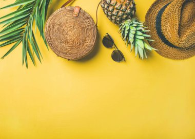 Renkli yaz kadın moda kıyafet. Hasır şapka, bambu çanta, güneş gözlüğü, hurma dalları, sarı arka plan üzerinde taze ananas