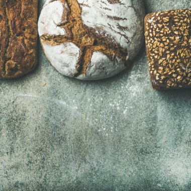Çeşitli seçim ekmek. Çavdar, buğday ve buğday rustik ekmek somunları gri arka plan üzerinde Üstten Görünüm