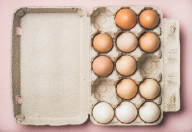 Paskalya tatili arka plan. Doğal yumurta kutusundaki renkli açık pembe renkli, üstten görünüm, yatay kompozisyon üzerinde