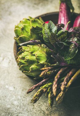 Yeşil ve mor sebze gri arka plan üzerinde plaka üzerinde