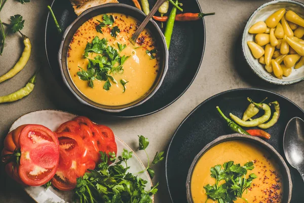 Flat-lay of Turkish traditional lentil soup Mercimek in black bowls with parsley, vegetable, flatbread, pickled peppers over grey concrete background, top view. Vegan, Oriental, Middle Eastern cuisine — Stock Image Flat Lay Turkish Traditional Lentil Soup Mercimek Black Bowls Parsley Royalty Free Stock Photos
