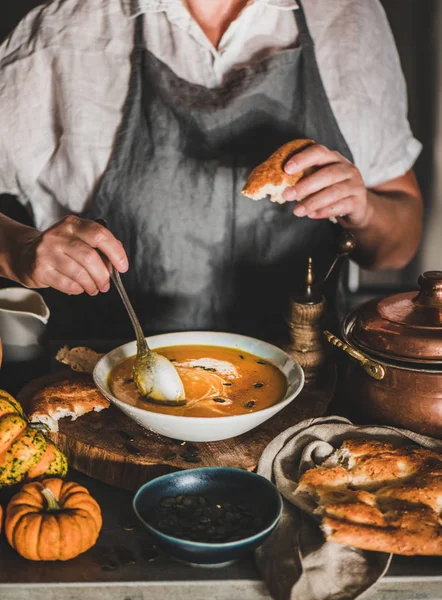 Mujer mezclando crema con sopa de crema de calabaza con cuchara — Foto de Stock