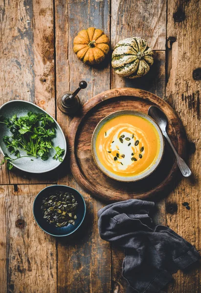 Тыквенный суп с семенами, свежей петрушкой и сливками в миске — стоковое фото