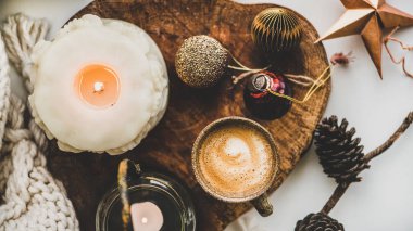 Noel şenlik havası kompozisyonu, kır evinde kahve, mumlar ve tahta tahtada dekoratif oyuncaklar beyaz yün battaniye arka planı, üst manzara, yakın çekim. Noel tebrik kartı.