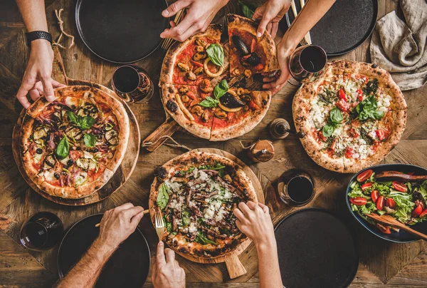 Flat-lay de pessoas que têm jantar de festa de pizza com vinho tinto — Fotografia de Stock