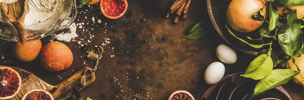 血液オレンジケーキ成分 新鮮なオレンジのフラットレイ レモン 小麦粉 シナモンと錆びた暗いテーブルの背景にケーキ型 トップビュー コピースペース 広い組成 ヘルシーな季節のベーキング — ストック写真