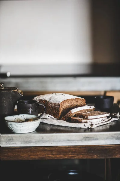 健康的なライ麦スウェーデンのパンのローフは キッチンカウンターの上に綿タオルでヴィンテージナイフで小麦粉で覆われたスライスでカット 選択的な焦点 — ストック写真